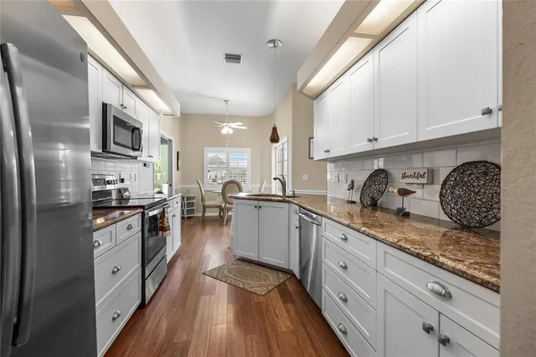 a large kitchen with stainless steel appliances granite countertop a stove a sink dishwasher and a refrigerator