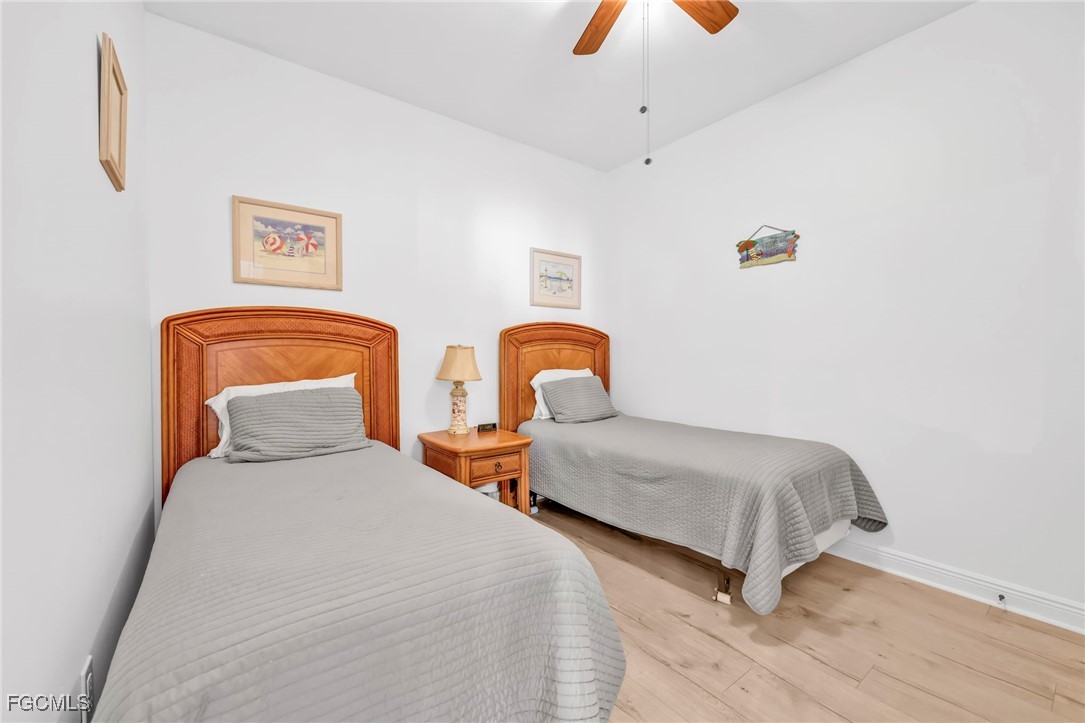 2743 First Street, Unit 1206 Fort Myers, FL 33916 - Photo 32 of 50 a bedroom with two beds and a chandelier
