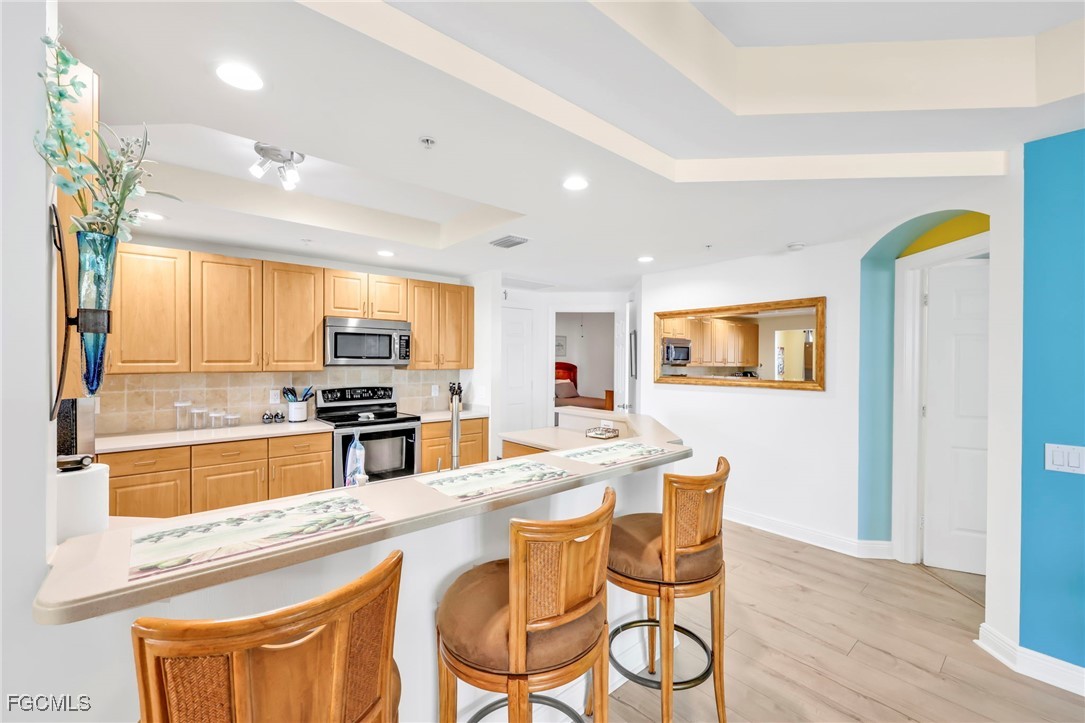 2743 First Street, Unit 1206 Fort Myers, FL 33916 - Photo 6 of 50 a kitchen with stainless steel appliances granite countertop a stove top oven a sink a dining table and chairs with wooden floor