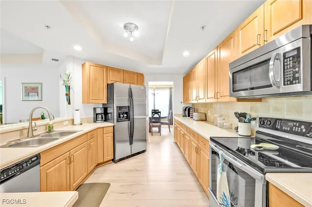 a large kitchen with stainless steel appliances granite countertop a lot of counter space a sink and a refrigerator