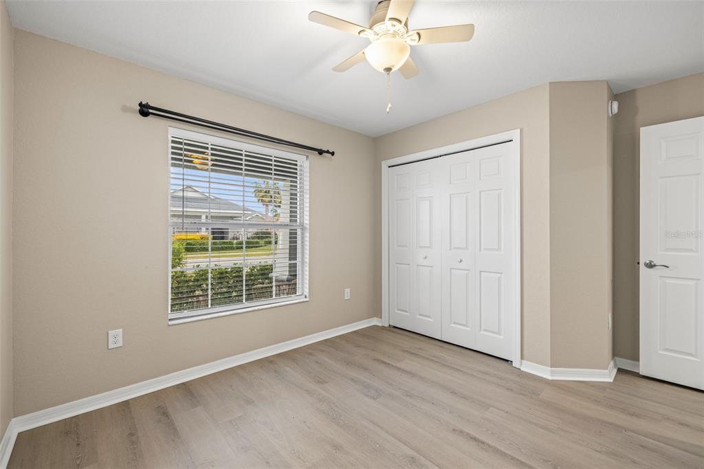 3878 White Ibis Road Lakeland, FL 33811 - Photo 16 of 21 an empty room with wooden floor fan and windows