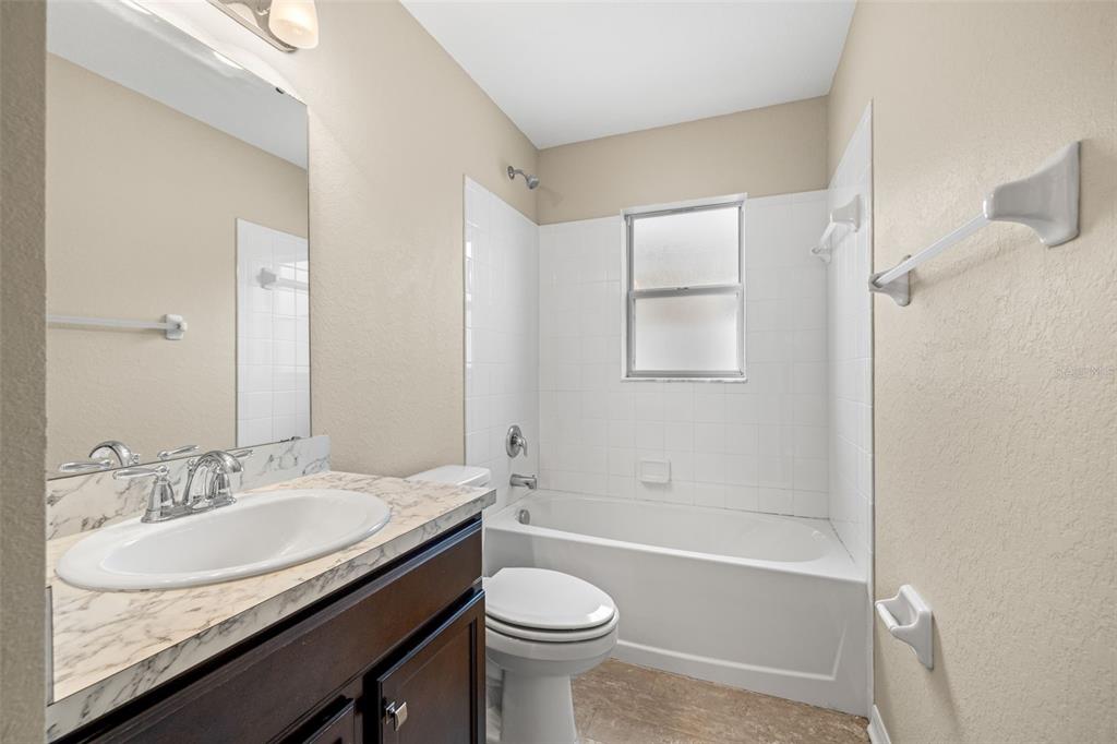 3878 White Ibis Road Lakeland, FL 33811 - Photo 17 of 21 a bathroom with a granite countertop sink toilet and shower