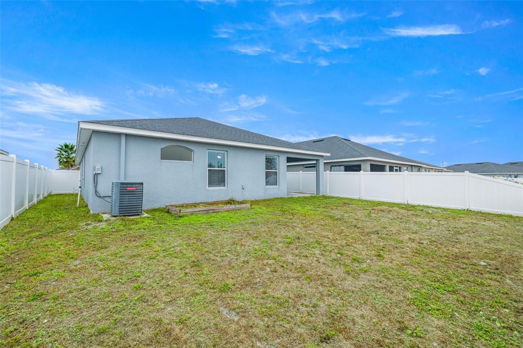 3878 White Ibis Road Lakeland, FL 33811 - Photo 20 of 21 a backyard of a house with plants and wooden fence