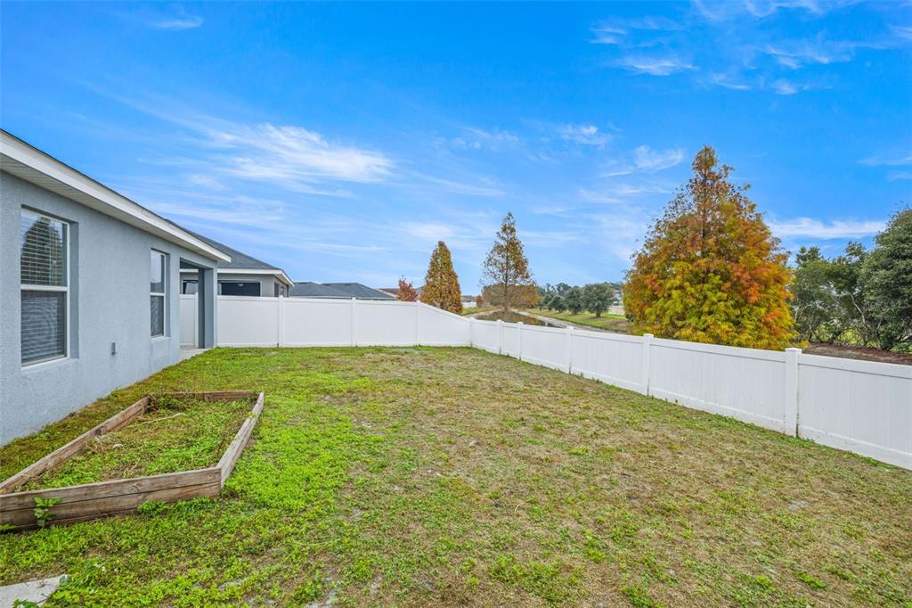 3878 White Ibis Road Lakeland, FL 33811 - Photo 21 of 21 a view of a backyard with plants and a lake view