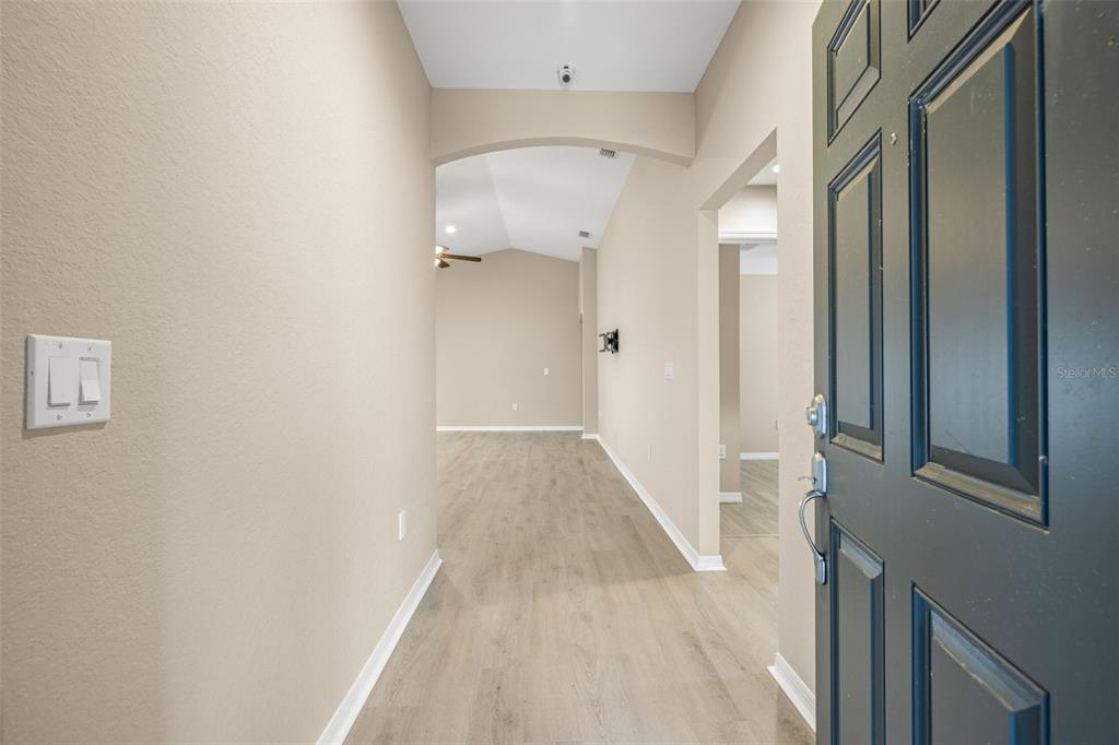 3878 White Ibis Road Lakeland, FL 33811 - Photo 3 of 21 a view of a hallway with wooden floor and staircase