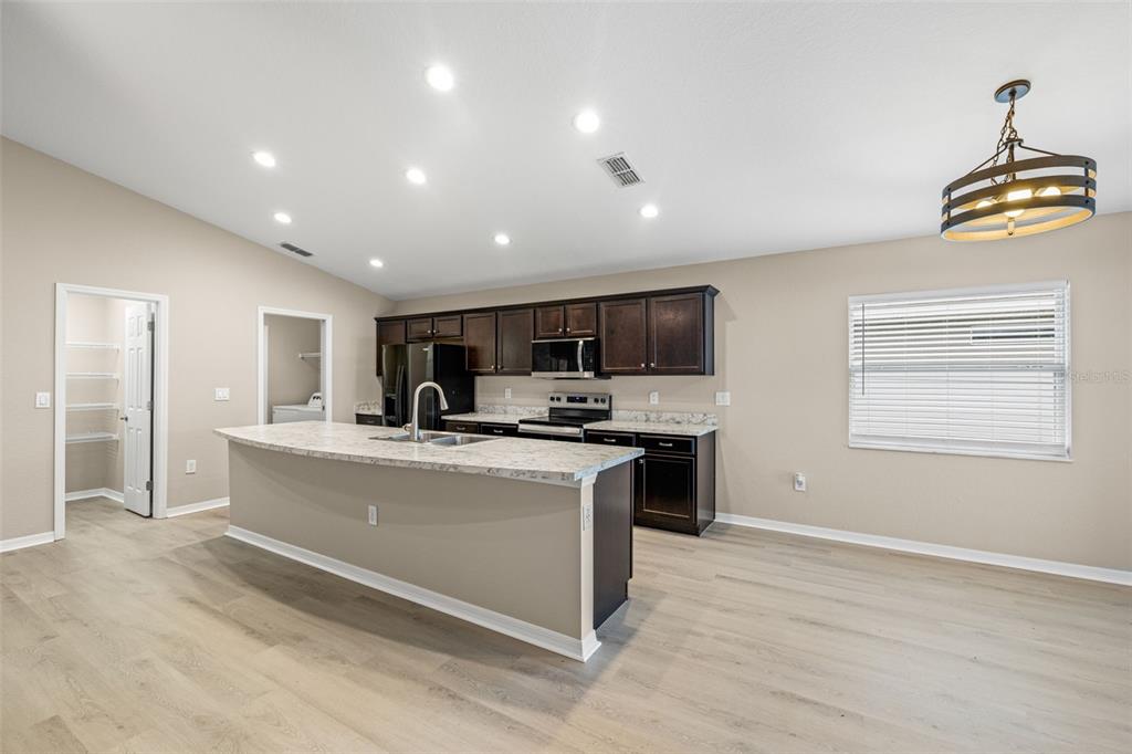 3878 White Ibis Road Lakeland, FL 33811 - Photo 5 of 21 a view of kitchen with stainless steel appliances granite countertop a stove top oven a sink a dining table and chairs