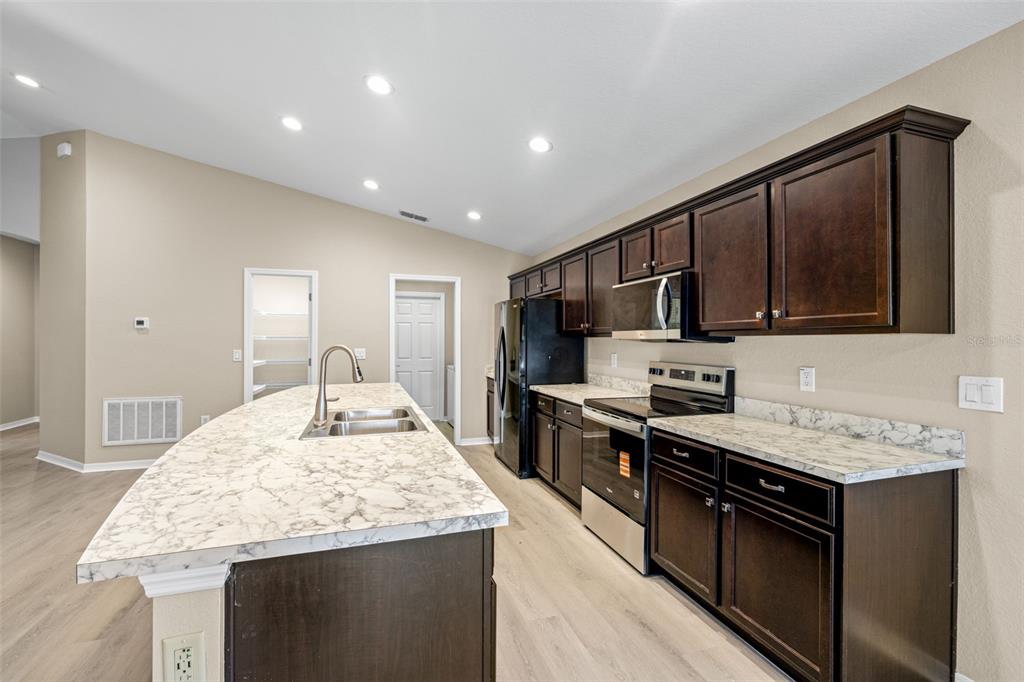 3878 White Ibis Road Lakeland, FL 33811 - Photo 6 of 21 a kitchen with stainless steel appliances granite countertop a sink stove and refrigerator