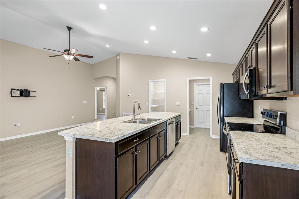 3878 White Ibis Road Lakeland, FL 33811 - Photo 8 of 21 a large kitchen with stainless steel appliances granite countertop plenty wooden cabinets counter space and wooden floor
