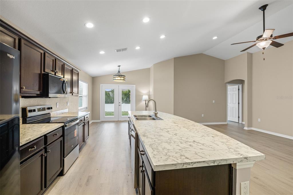 3878 White Ibis Road Lakeland, FL 33811 - Photo 9 of 21 a kitchen with stainless steel appliances granite countertop a sink stove and refrigerator