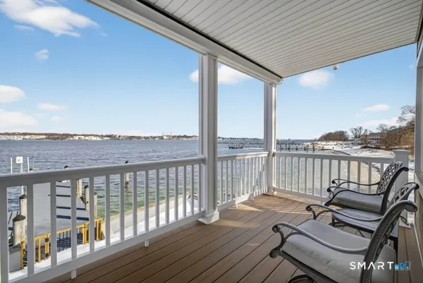a view of a balcony with wooden floor next to a yard