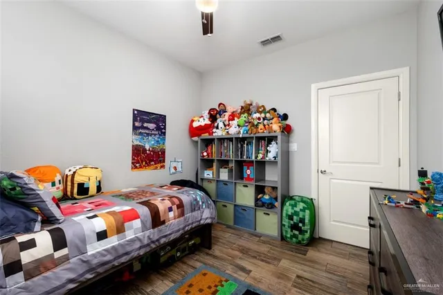 a bedroom with bed and wooden floor