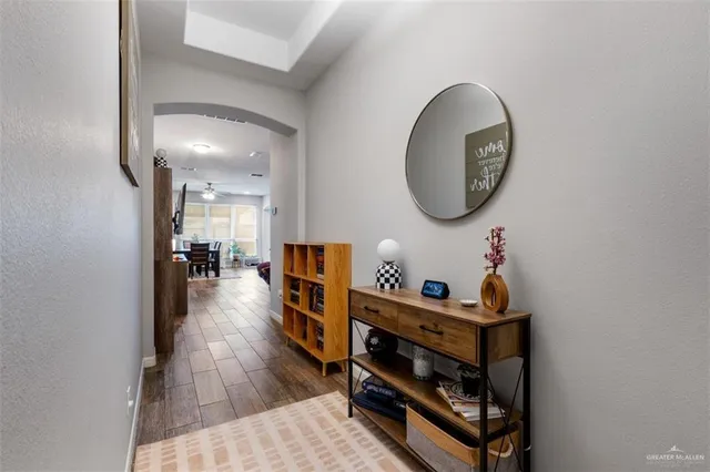 a hallway with a wooden floor a dining table and chairs