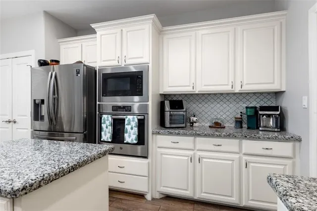 a kitchen with granite countertop a cabinets and steel stainless steel appliances