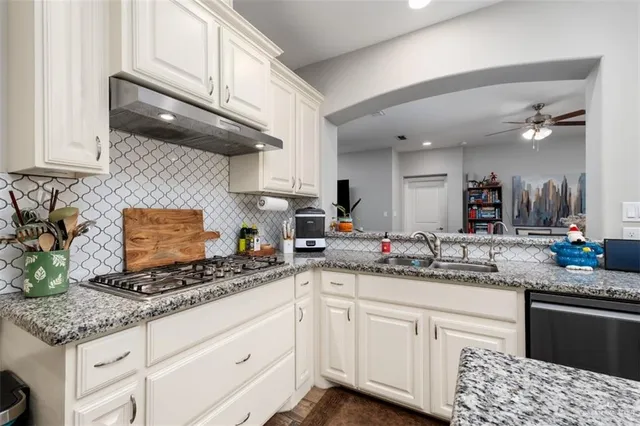 a kitchen with stainless steel appliances granite countertop a sink stove and cabinets