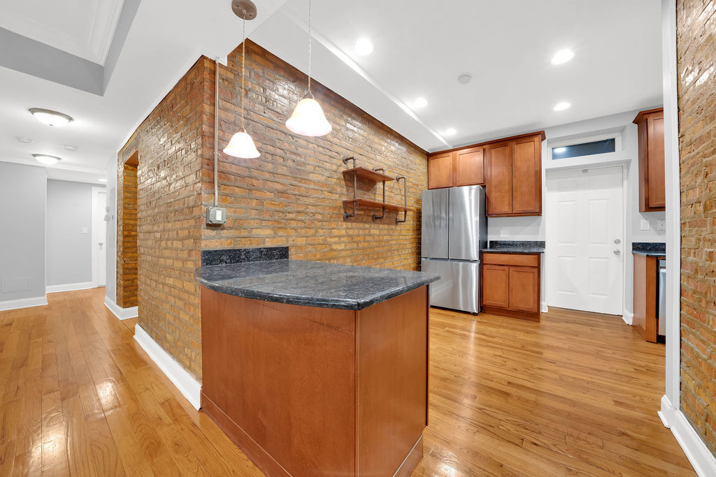 2256 West Arthur Avenue, Unit 2 Chicago, IL 60645 - Photo 5 of 22 a kitchen with stainless steel appliances granite countertop a sink and a refrigerator