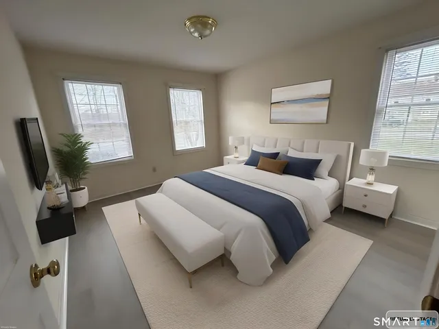 a bedroom with a bed and large windows