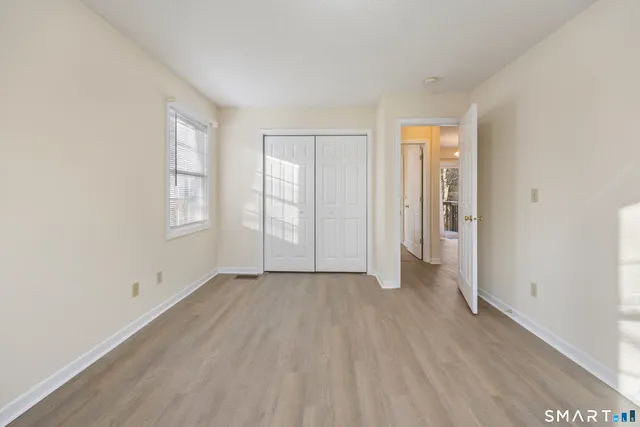 an empty room with windows and closet