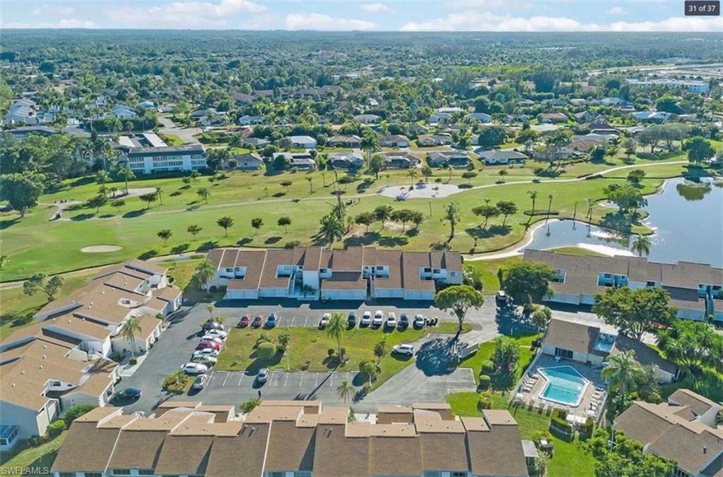 476 Bristle Cone Lane, Unit 39 Naples, FL 34113 - Photo 12 of 16 Aerial view of property and surrounding area featuring a golf course and a nearby body of water