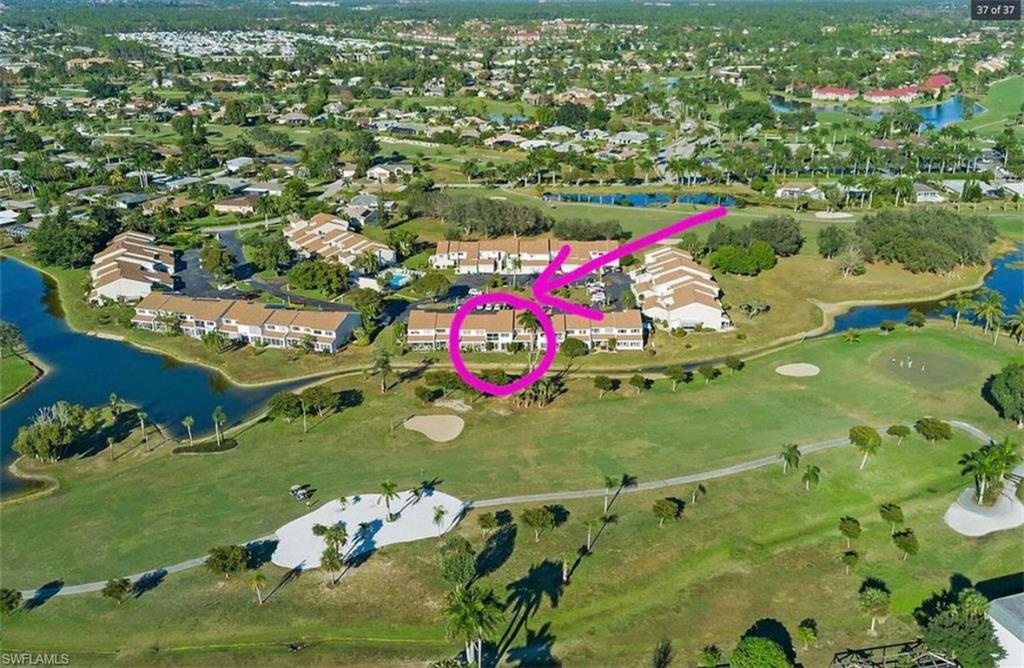 476 Bristle Cone Lane, Unit 39 Naples, FL 34113 - Photo 13 of 16 Aerial perspective of suburban area with a large body of water and a golf club