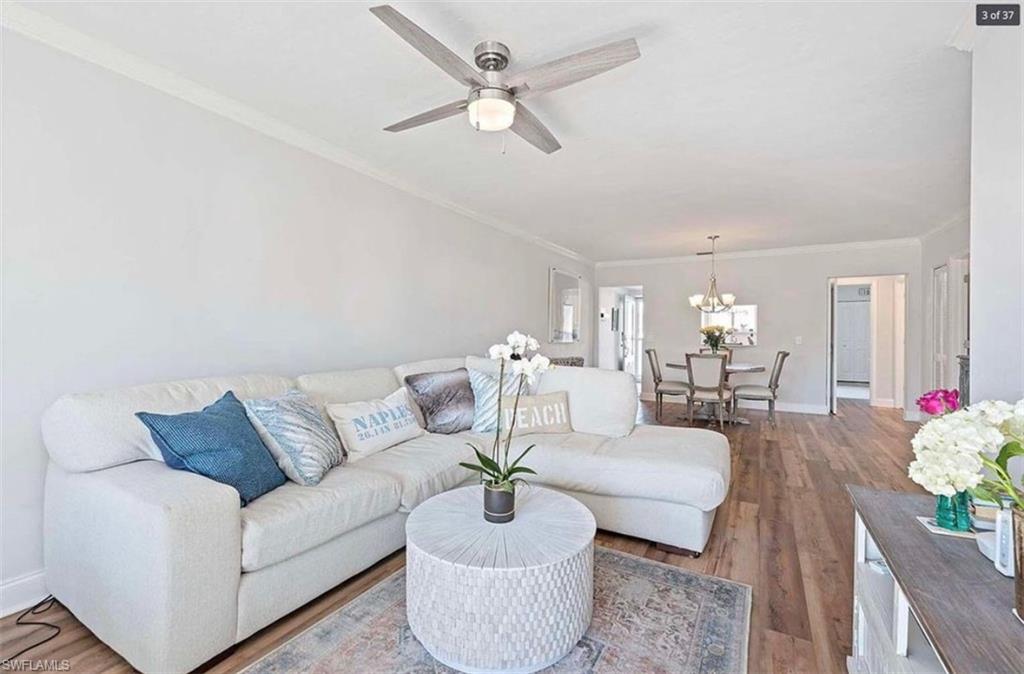 476 Bristle Cone Lane, Unit 39 Naples, FL 34113 - Photo 6 of 16 Living room with wood finished floors, ornamental molding, a ceiling fan, and suspended lighting