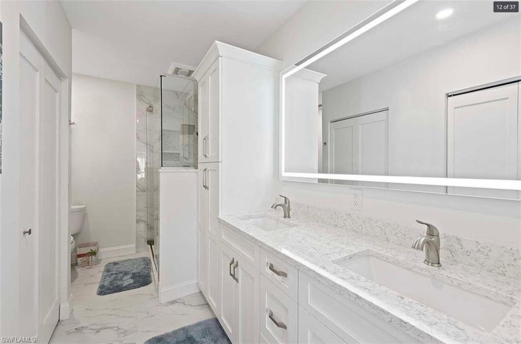 476 Bristle Cone Lane, Unit 39 Naples, FL 34113 - Photo 9 of 16 Full bathroom featuring double vanity, a marble finish shower, and light marble finish floors