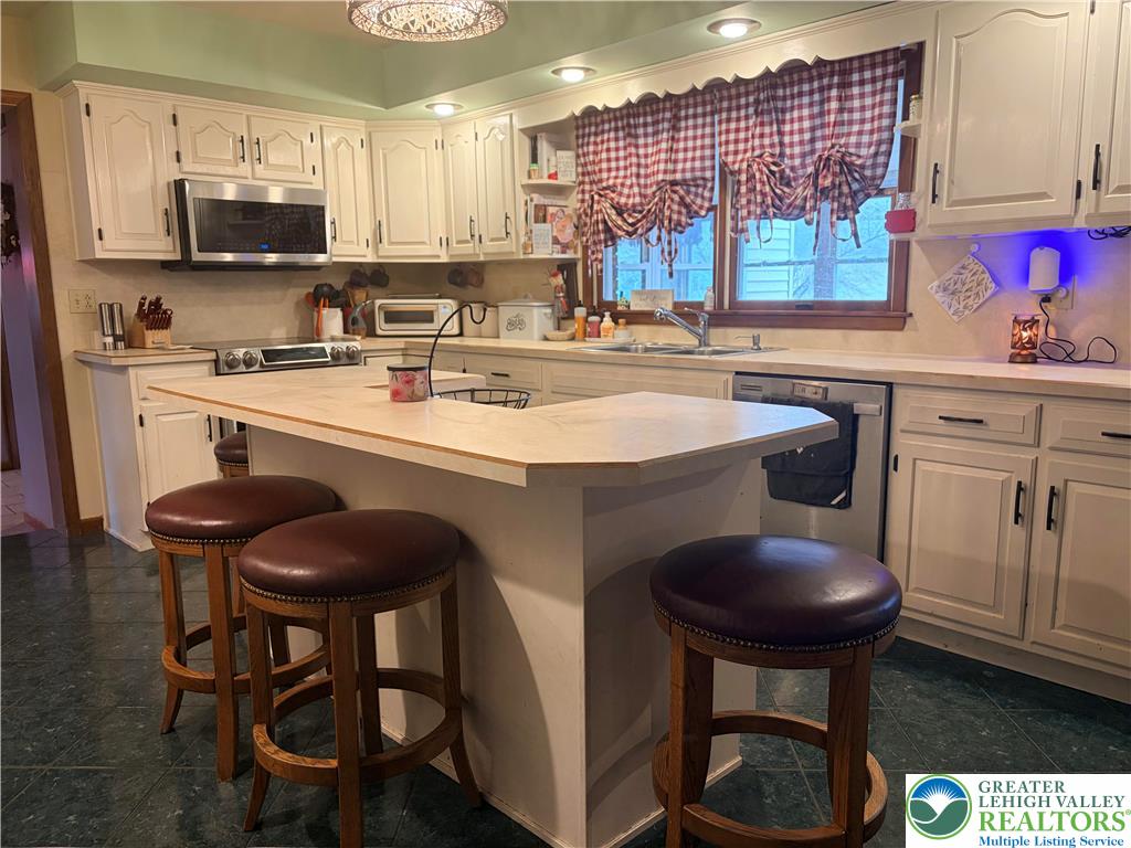 100 Hazelwood Road Lehighton, PA 18235 - Photo 13 of 31 a kitchen with stainless steel appliances kitchen island a table chairs sink and cabinets