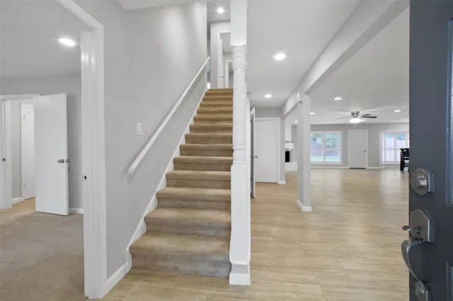 an empty room with windows and ceiling fan