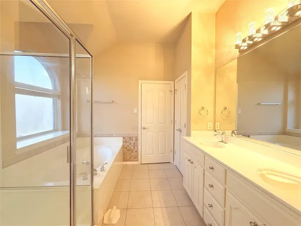 a spacious bathroom with a granite countertop sink and a bathtub