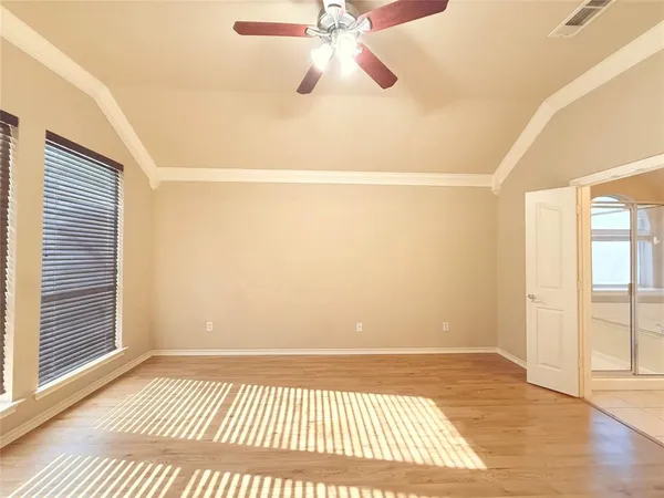 a view of an empty room with window and wooden floor
