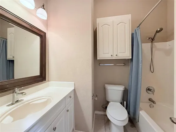 a bathroom with a toilet a sink a tub and mirror