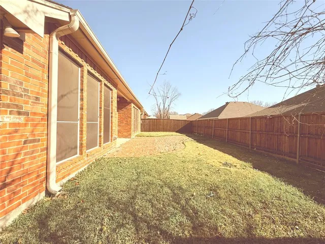 a view of backyard with wooden fence