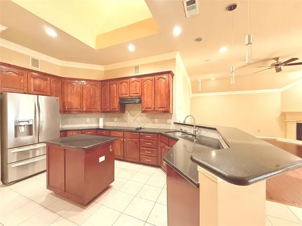 a kitchen with kitchen island granite countertop a sink counter top space and stainless steel appliances