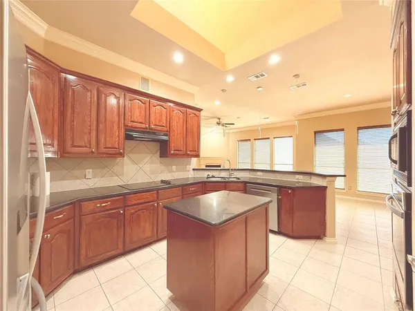 a large kitchen with kitchen island granite countertop a sink dishwasher stove and cabinets