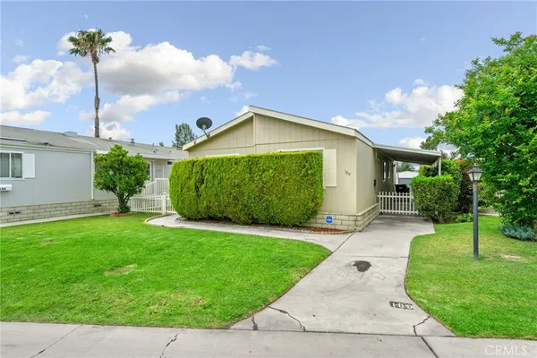 a front view of a house with a yard and potted plants
