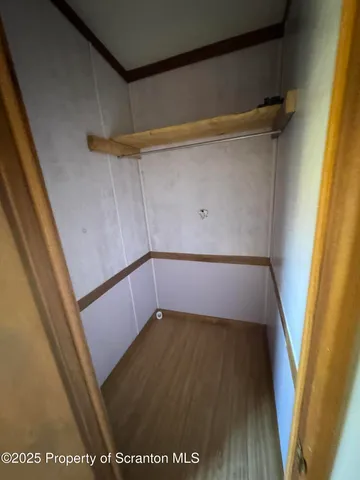 a view of walk in closet with wooden floor