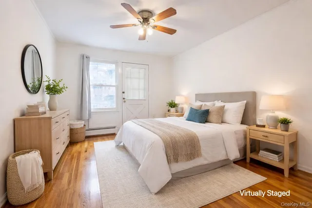 a bedroom with a bed a dresser with wooden floor