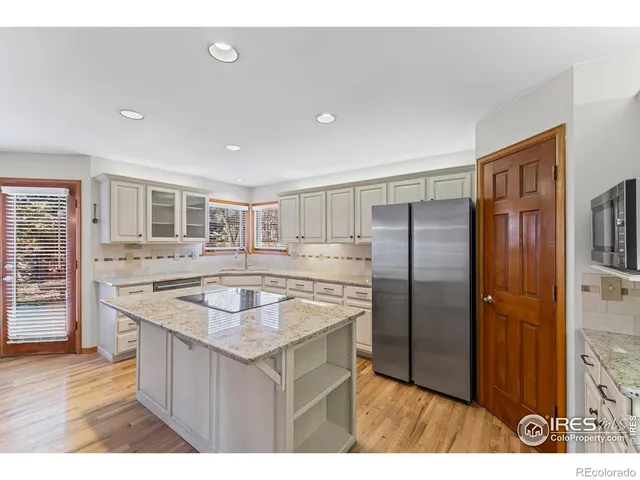 a kitchen with stainless steel appliances granite countertop a sink a refrigerator and a stove