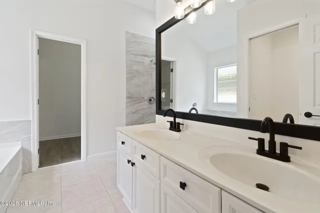 a bathroom with double sink and two mirror