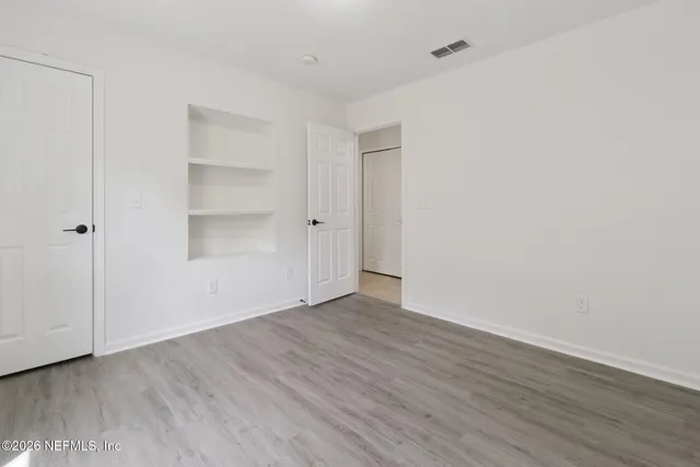 a view of an empty room with wooden floor