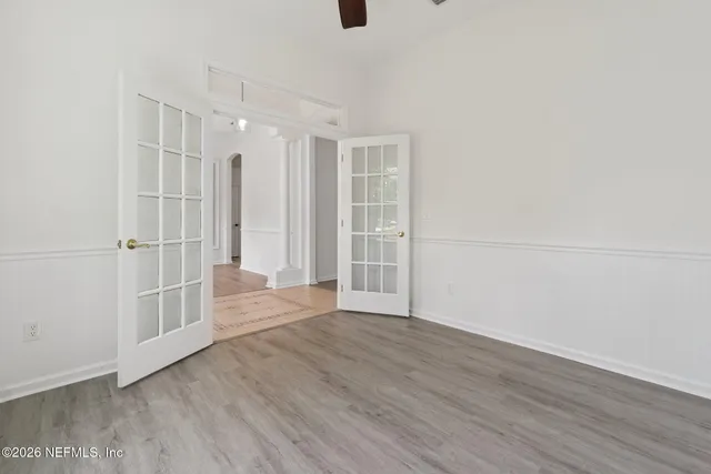 an empty room with wooden floor and windows