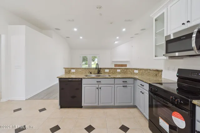 a kitchen with granite countertop a sink and a stove top oven