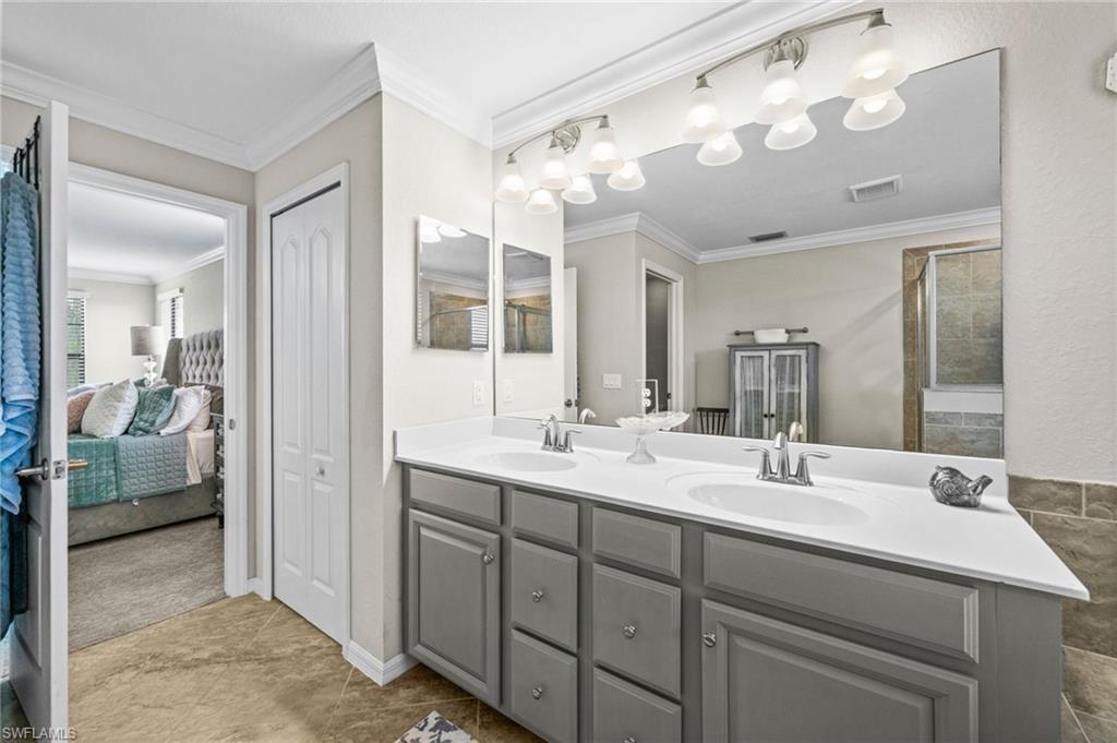 4754 Abaca Circle Naples, FL 34119 - Photo 22 of 46 a en suite bathroom with double sink and a mirror