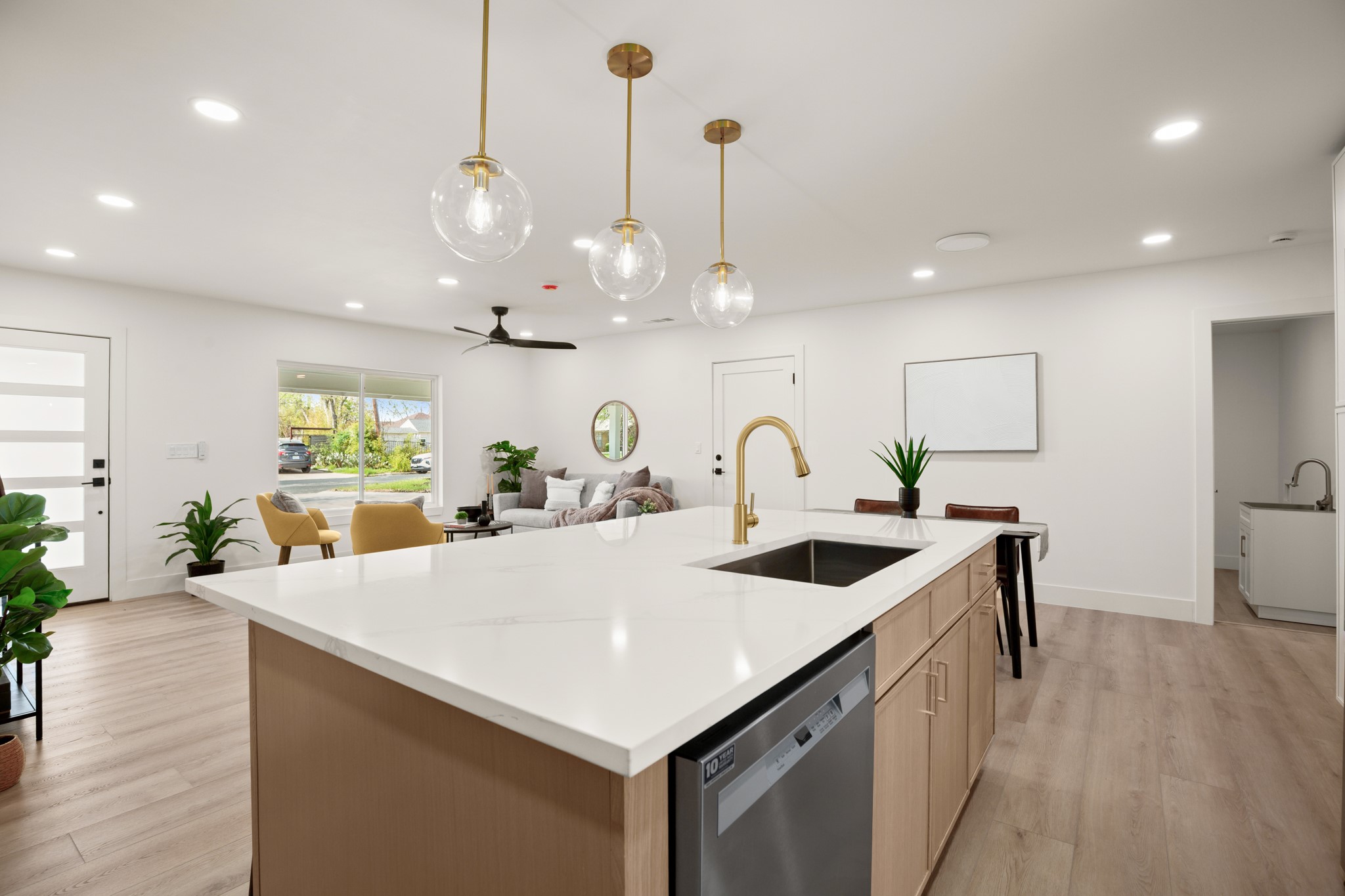 3308 Touchstone Street Austin, TX 78723 - Photo 10 of 38 Kitchen with a center island with sink, ceiling fan, dishwasher, and light wood finished floors