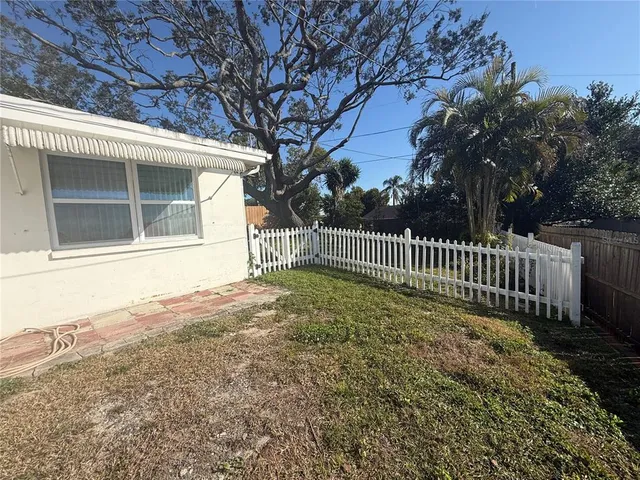 a view of a house with a small yard and a large tree