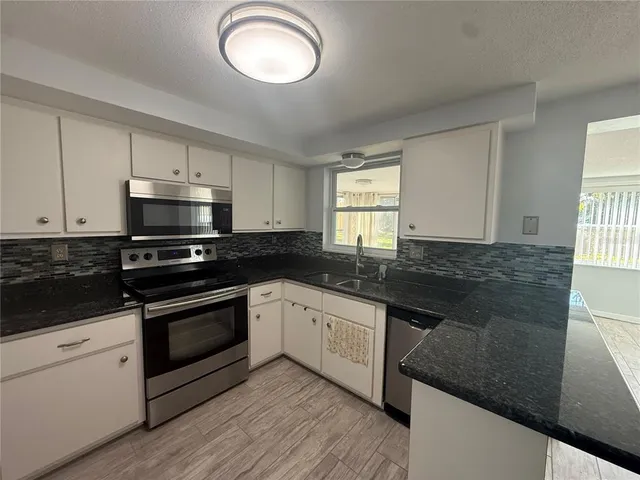 a kitchen with granite countertop a stove and a sink