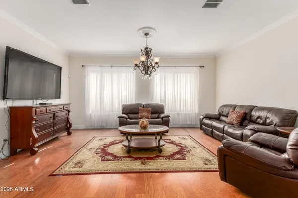 a dining room with furniture a chandelier and wooden floor