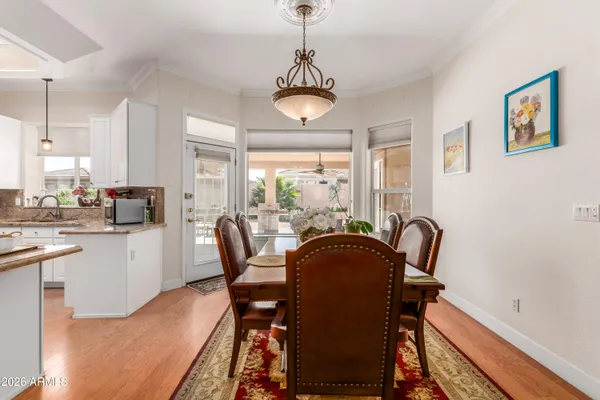 a dining room with furniture a chandelier and wooden floor