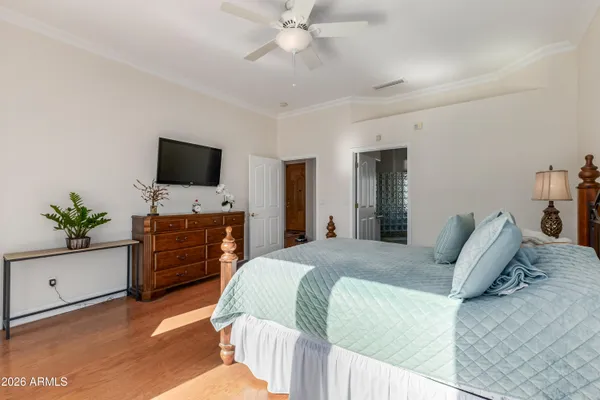 a bedroom with a large bed and a flat tv screen on dresser