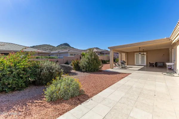 a front view of a house with a yard and mountain view