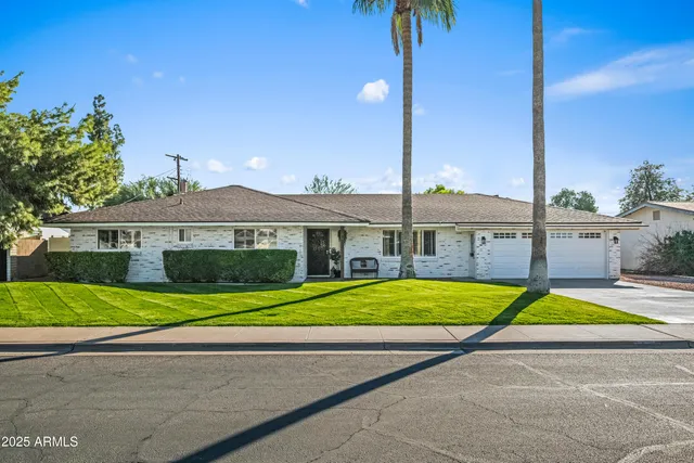 a front view of a house with a yard and potted plants